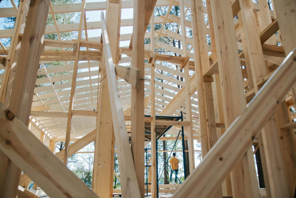pexels-photo-8830259-8830259 Interior view of wooden house frame under construction with visible scaffolding.